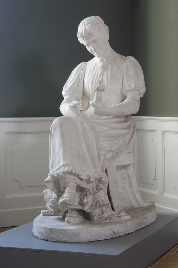 Female Sculptor sitting with a Statuette in her Hands